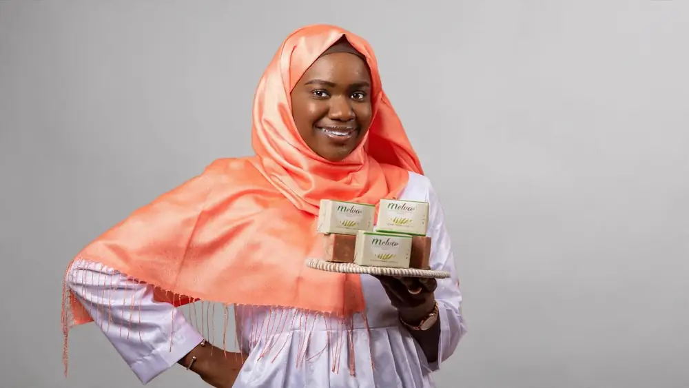 Femme souriante présentant des savons naturels Melva